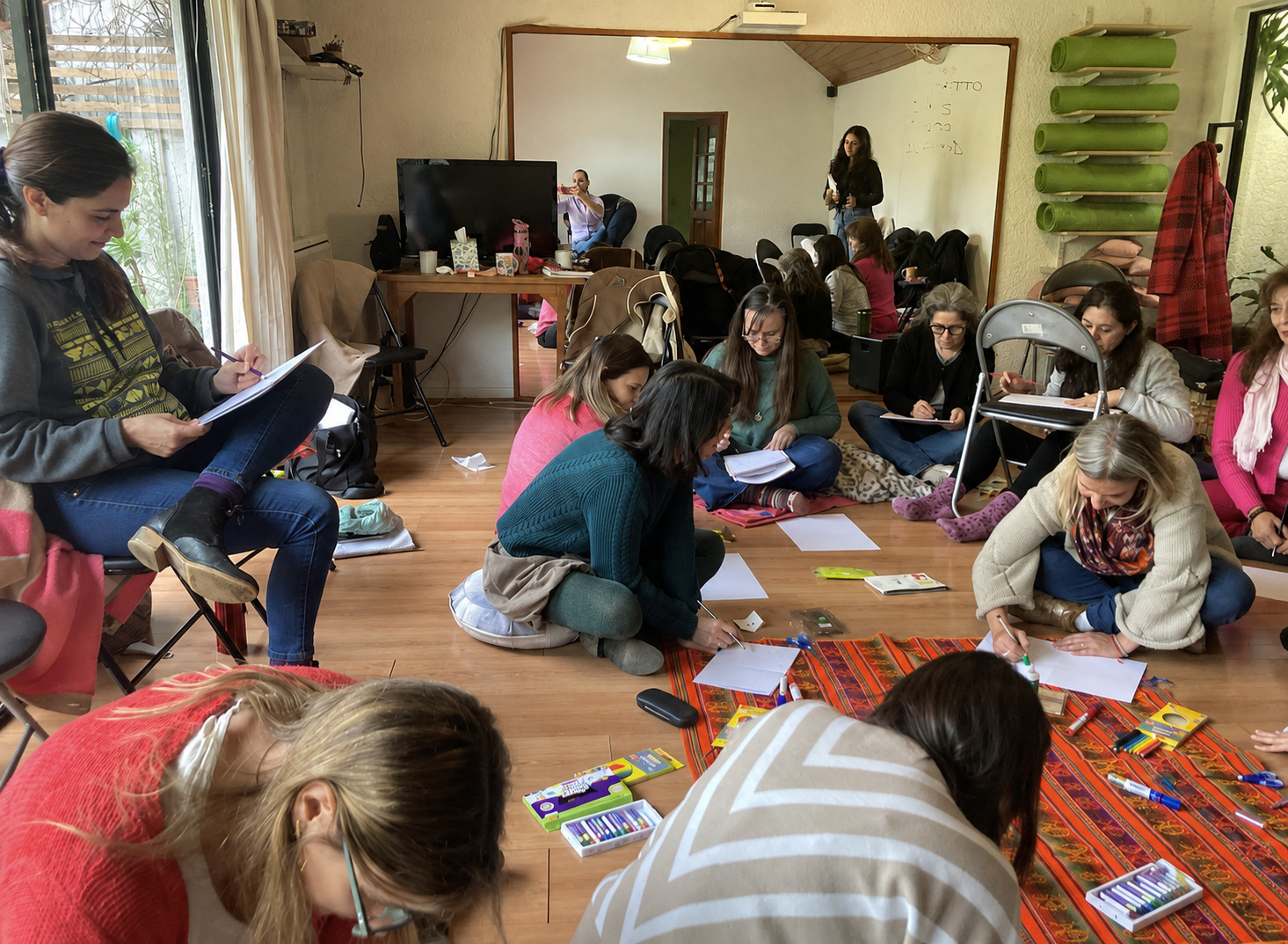Participantes de la formación Ética y Trauma trabajando con materiales en el suelo